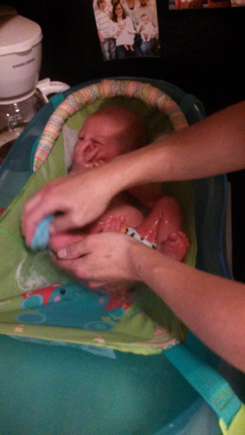 1979 Ford Bronco - Baby is being bathed in a bath seat with a washcloth.
