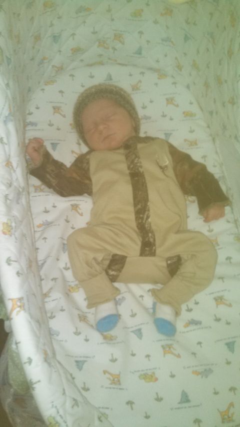1979 Ford Bronco - A baby sleeps soundly in a crib, dressed in a camouflage outfit and a knit cap.