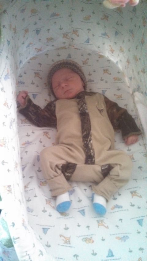 1979 Ford Bronco - A baby sleeps soundly in a bassinet, dressed in a camouflage-patterned outfit.
