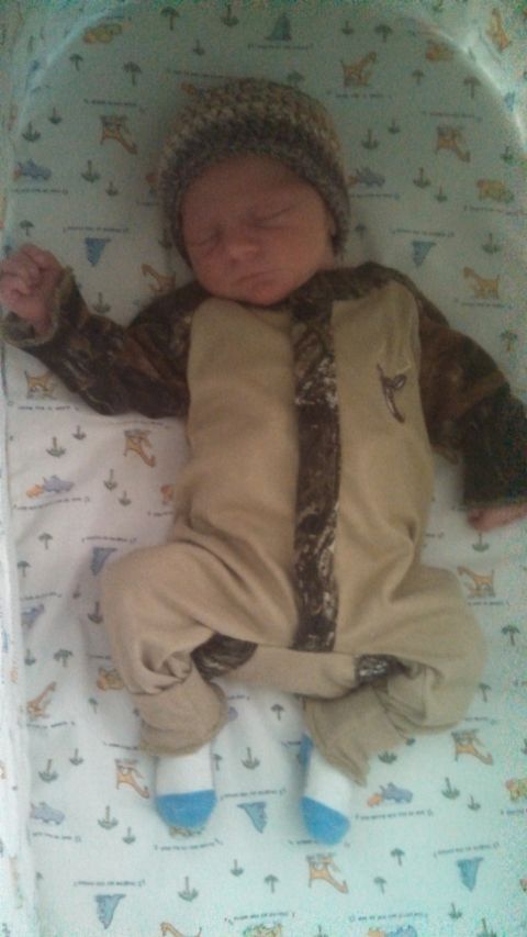 1979 Ford Bronco - A baby sleeps soundly in a crib, dressed in a camouflage-patterned onesie and a knit cap.