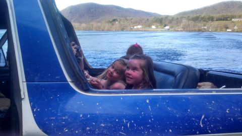 1979 Ford Bronco - Children enjoy a ride on the water, seen from inside a blue vehicle.