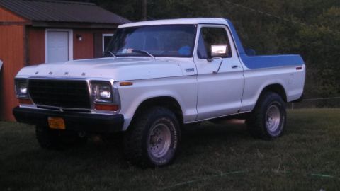 1979 Ford Bronco - This 1979 Ford Bronco features a white body with a contrasting blue top and is shown from a 3/4 front angle.