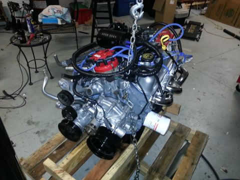 1994 Ford Bronco - Engine assembly, likely a Ford V8, is suspended by chains and resting on wooden pallets.