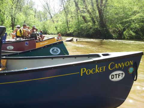 2003 Nissan Frontier - Several canoes are on a river with people in them, surrounded by trees.