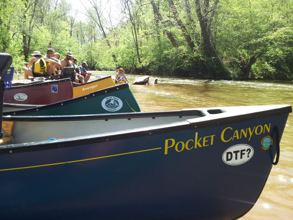 Blue canoe with yellow text 'Pocket Canyon' and 'DTF?' sticker on a river