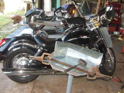 1998 Honda Shadow VT750C - A black motorcycle is being worked on in a garage, with another motorcycle in the background.