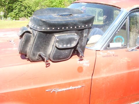 1998 Honda Shadow VT750C - Motorcycle saddlebag rests on the hood of a red car, possibly a Ranchero, with handwritten notes.