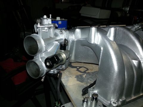 1994 Ford Bronco - This photo shows a disassembled engine part, specifically an intake manifold and throttle body, not a complete vehicle.