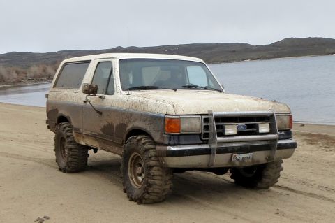1989 Ford Bronco - This 1987 Ford Bronco is covered in mud after an off-road excursion near a body of water.