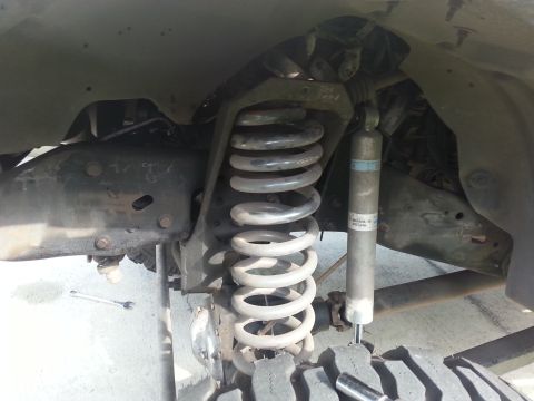 1992 Ford Bronco - Close-up view of a vehicle's front suspension system, showing the coil spring and shock absorber.