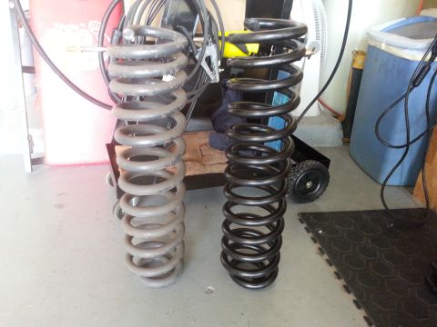 1992 Ford Bronco - Comparison of two coil springs, one appears to be used and the other new.