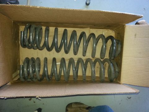 1992 Ford Bronco - Two sets of coil springs are shown inside a cardboard box, with some text visible on the springs themselves.