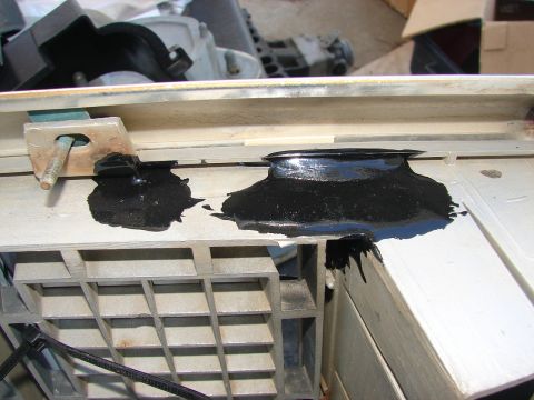 1973 Ford Ranchero - Black sealant is applied to a section of a gray plastic automotive component.
