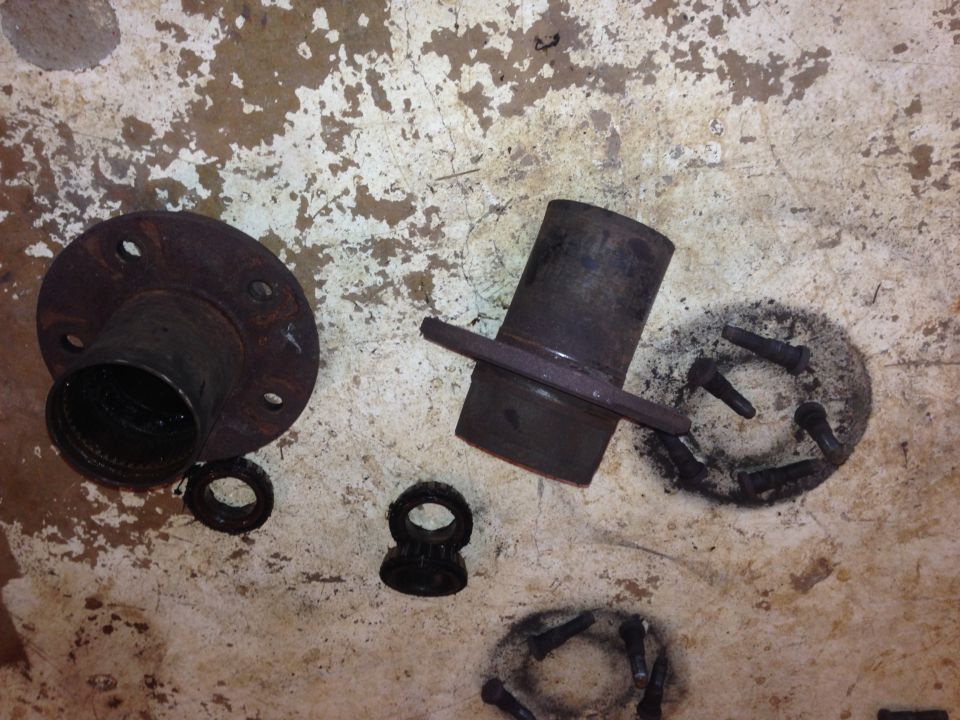 Rusty brake rotor and hub assembly parts on a concrete floor