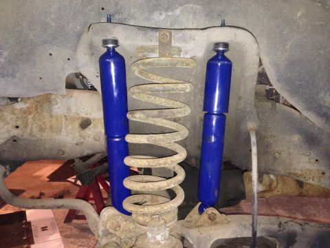 1990 Ford Bronco - Front suspension components including blue shock absorbers and a coil spring are shown.