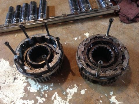 1990 Ford Bronco - Two used automatic locking hubs are shown on a workbench with a socket wrench set nearby.