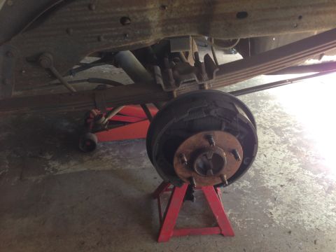 1990 Ford Bronco - Close-up of a vehicle's rear drum brake assembly being worked on.