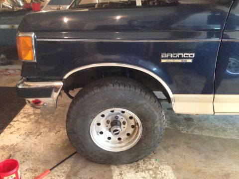 1990 Ford Bronco - Front view of a 1990 Ford Bronco showing its wheel, fender, and side trim.