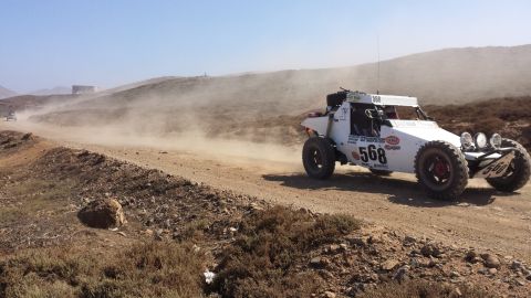 1996 Ford Bronco - A buggy competes in a desert race, leaving a trail of dust on the arid terrain.