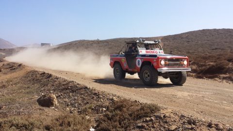1996 Ford Bronco - This modified Ford Bronco races off-road, kicking up a cloud of dust on a sunny day.