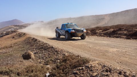 1996 Ford Bronco - A modified truck races down a dusty desert road.