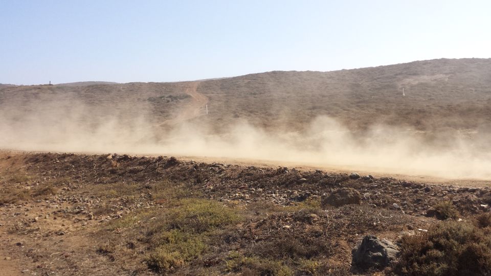 Dust cloud kicked up by an off-road vehicle on a dirt track
