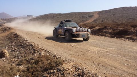 1996 Ford Bronco - A modified rally car navigates a dusty off-road course, likely during a desert race event.