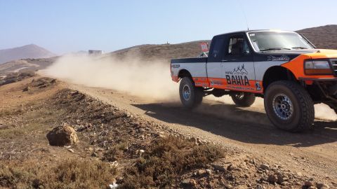 1996 Ford Bronco - Off-road race truck, a 1996 Ford F-150, kicks up dust on a dirt track.