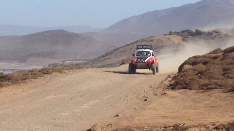 1996 Ford Bronco - An off-road buggy navigates a dusty desert track during a race.