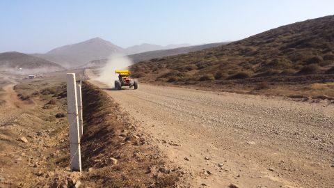 1996 Ford Bronco - A single buggy races down a dusty road, leaving a trail of dust in its wake.
