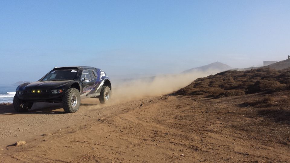 Black off-road race truck on dusty track
