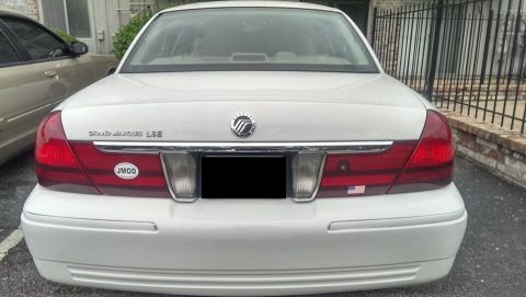 2000 Mercury Grand Marquis - The rear of a white 2000 Mercury Grand Marquis LSE is shown, the LSE badging and a JMOD sticker on the left taillight housing.