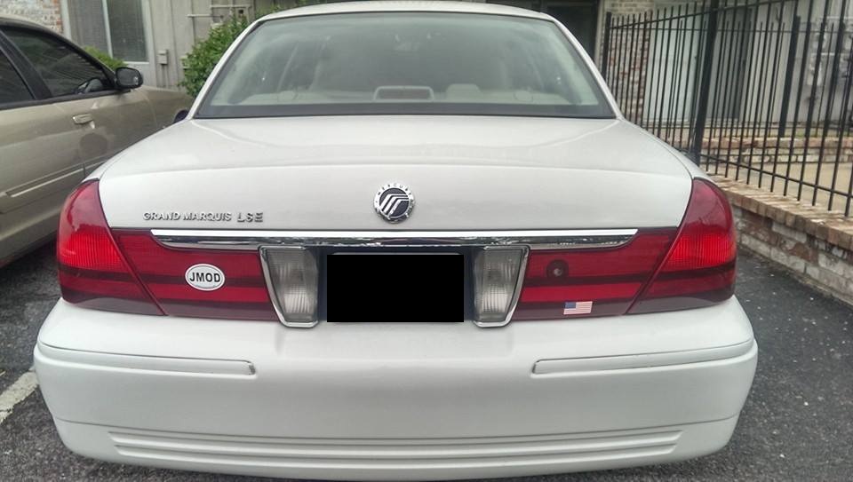 Rear view of a white 2000 Mercury Grand Marquis LSE with a JMOD sticker