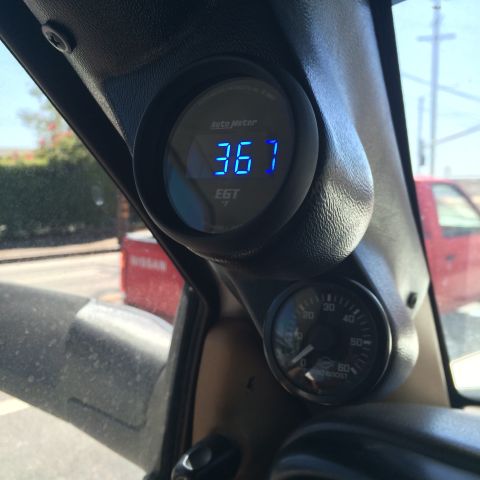 1997 Dodge 3500 - Interior view of an EGT and boost gauge, with a red truck seen through the windshield.