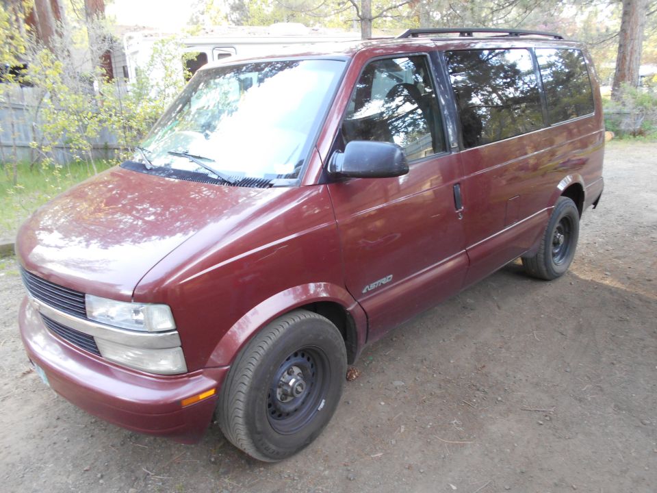 Maroon Chevrolet Astro van, 3/4 front view, parked outdoors on dirt