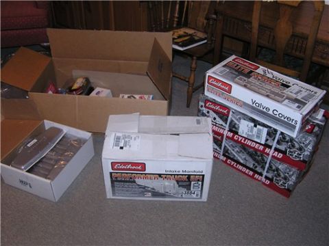 1993 Ford Bronco - A stack of new Edelbrock boxes on a living room floor: an Elite Series 'Valve Covers' box, two 'Aluminum Cylinder Head' cartons and a Perfo…
