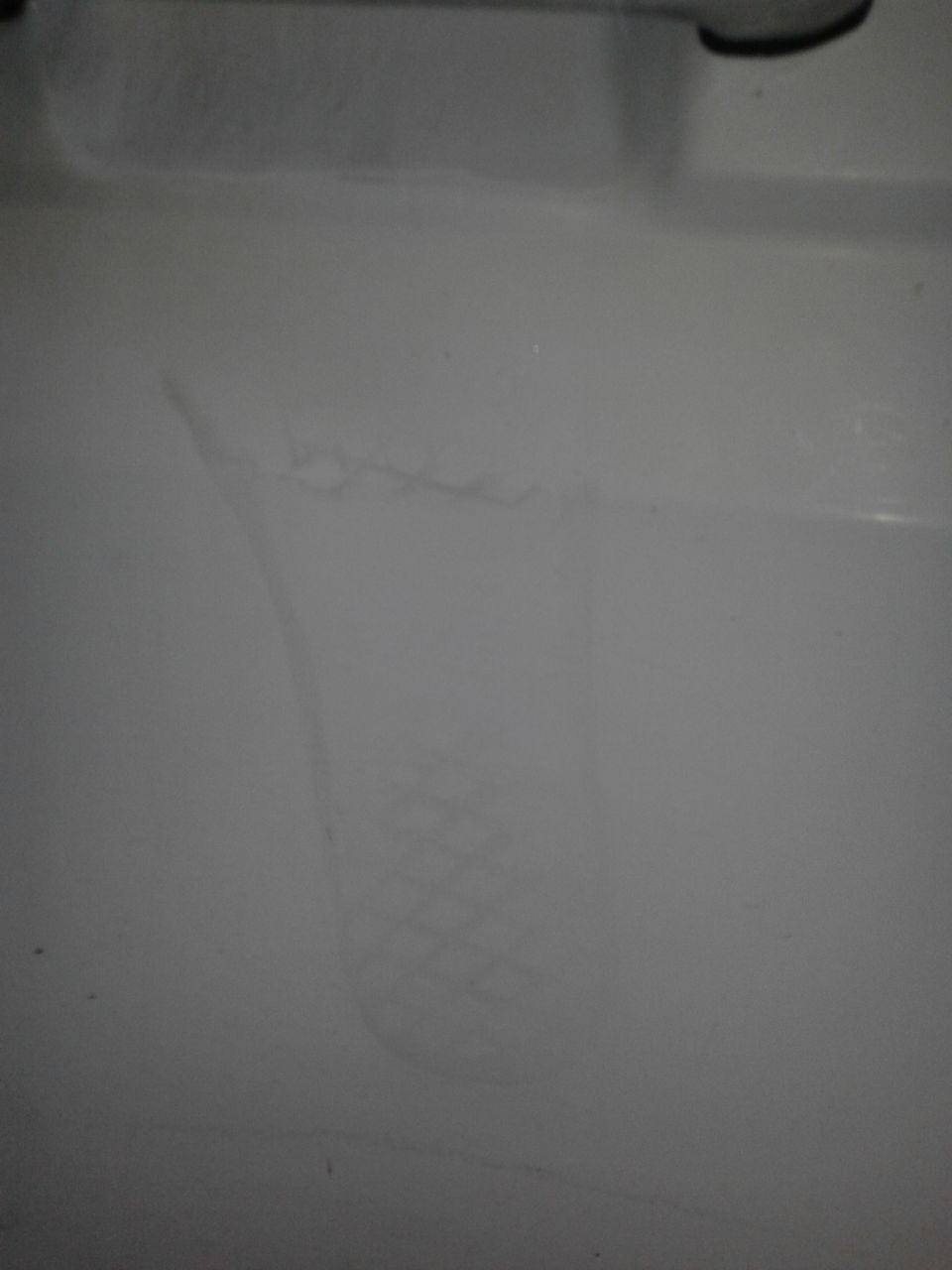 Faint tire tread imprint on a white surface