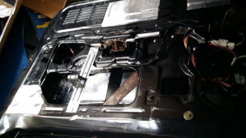 1994 Ford Bronco - Interior of a car door is disassembled, revealing the window regulator and wiring.