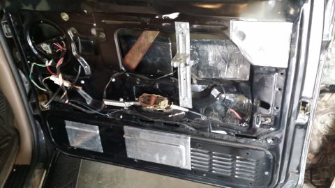 1994 Ford Bronco - The interior of a car door is shown with soundproofing material and exposed wiring, suggesting a modification or repair.