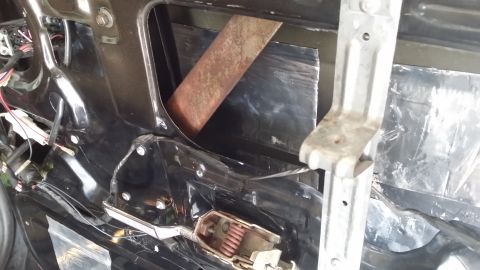 1994 Ford Bronco - The interior of a car door is visible, revealing the window regulator and sound deadening material.
