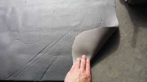 1994 Ford Bronco - Sound deadening material is being removed from the floor of a vehicle.