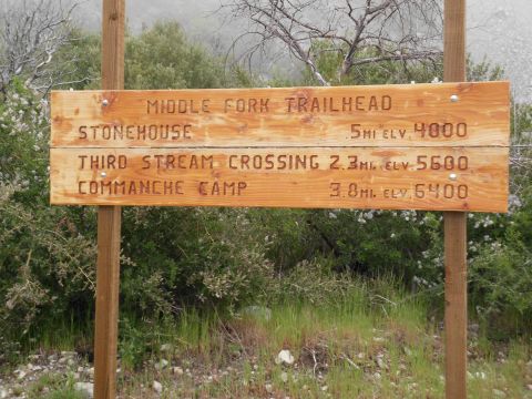 1988 Ford Bronco - Wooden trail sign lists destinations like Stonehouse and Commanche Camp with distances and elevations.