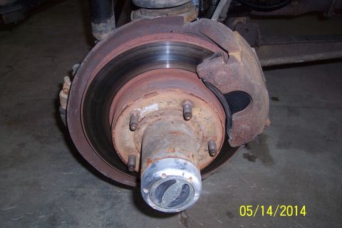 1978 Ford Bronco - Close-up of a heavily rusted front wheel hub and brake assembly, indicating a need for maintenance.