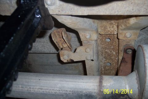1978 Ford Bronco - Close-up view of the undercarriage of a vehicle, showing rusty metal parts and an exhaust pipe.