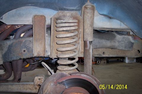 1978 Ford Bronco - Close-up view of the front suspension components, including a coil spring and shock absorber.