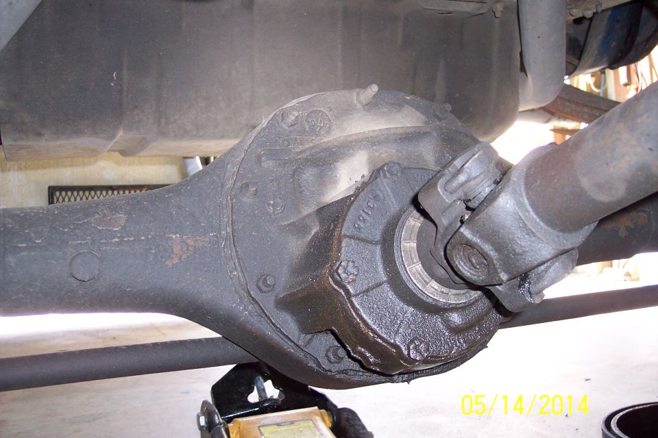 Rear differential housing with driveshaft attached, supported by a jack