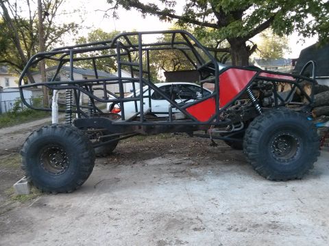 1986 Ford Bronco - This custom buggy is built on a tube frame with large off-road tires and red body panels.