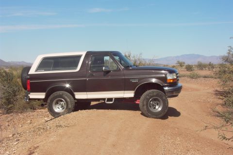 1992 Ford Bronco - This 1992 Ford Bronco is shown in a desert landscape, highlighting its side profile and off-road tires.
