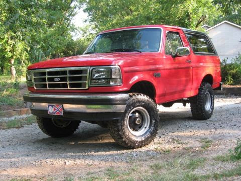 1992 Ford Bronco - This red 1992 Ford Bronco is shown from a three-quarter front view, parked outdoors.