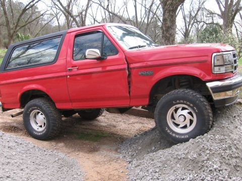 1992 Ford Bronco - Red 1992 Ford Bronco navigating a rocky trail.